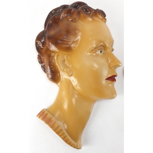 675 - Two hand painted Art Deco plaster wall masks, both of females, the largest 33cm high