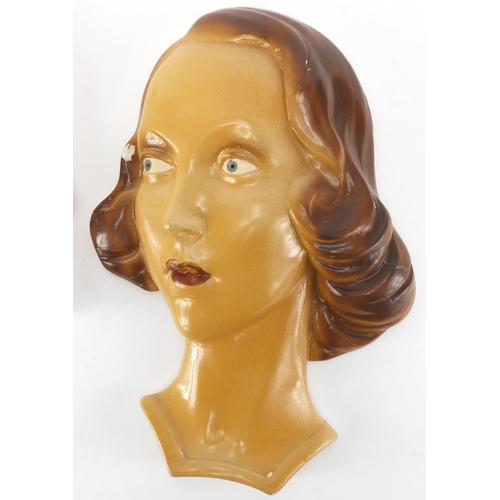 675 - Two hand painted Art Deco plaster wall masks, both of females, the largest 33cm high