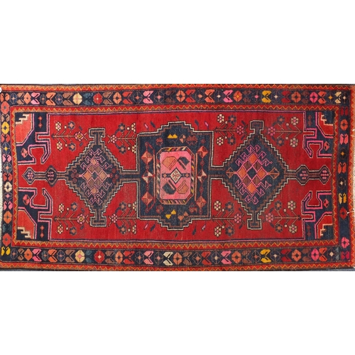 2010 - Rectangular Persian tribal rug, onto a red ground, 219cm x 118cm