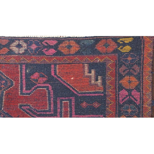 2010 - Rectangular Persian tribal rug, onto a red ground, 219cm x 118cm