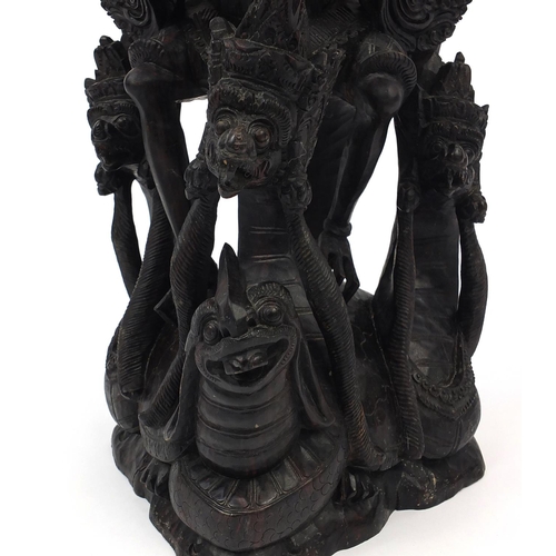 567 - Large well detailed Balinese hardwood figure group, carved with figures riding a turtle, 74cm high