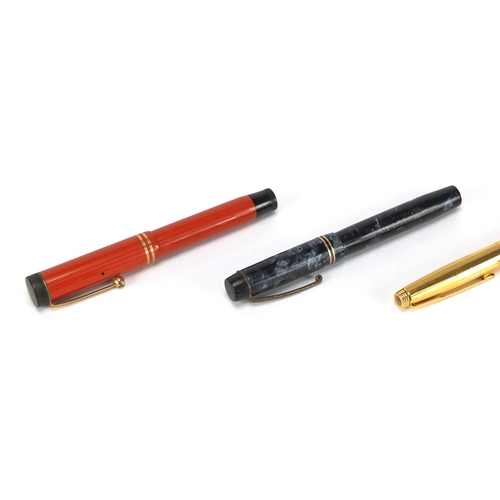 66 - Four fountain pens including an orange Parker Duofold lucky curve, red marbleised Conway Stewart No.... 