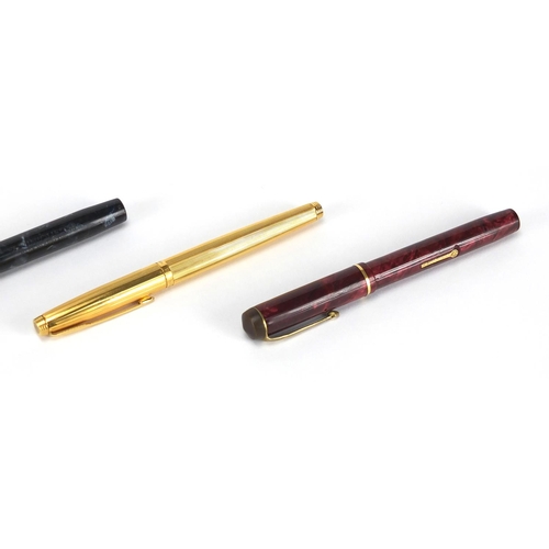 66 - Four fountain pens including an orange Parker Duofold lucky curve, red marbleised Conway Stewart No.... 