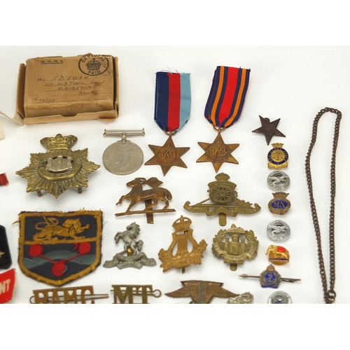 306 - British Militaria including World War II militaria including medal, cloth insignia, cap badges, silv... 