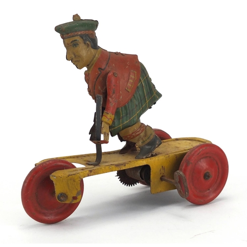 409 - German tin plate clockwork figure on a tricycle, 14cm high