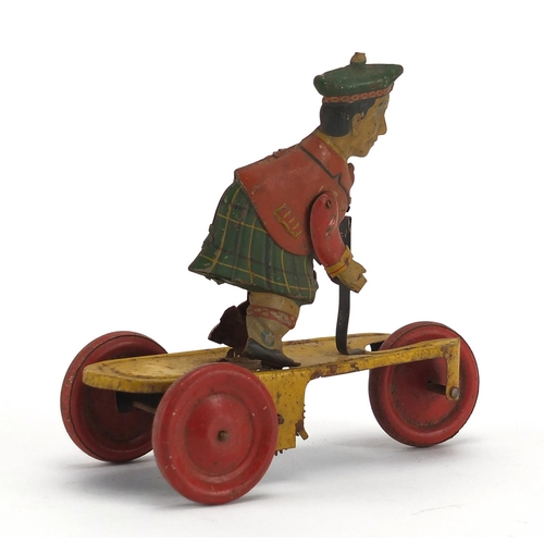 409 - German tin plate clockwork figure on a tricycle, 14cm high