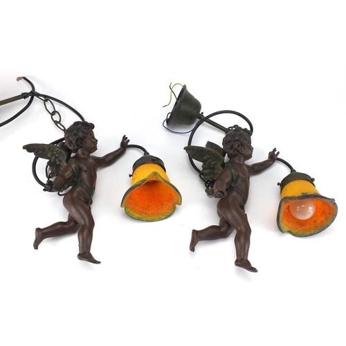 2044 - Pair of bronze style cherub hanging lights with colourful glass shades, the cherubs 24cm in length
