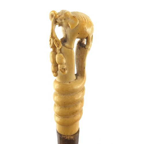 134 - Elephant whip with ivory handle, carved in the form of an elephant standing upon a cobra, 79cm in le... 