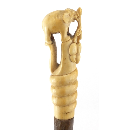 134 - Elephant whip with ivory handle, carved in the form of an elephant standing upon a cobra, 79cm in le... 