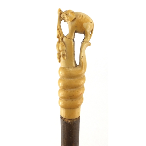 134 - Elephant whip with ivory handle, carved in the form of an elephant standing upon a cobra, 79cm in le... 