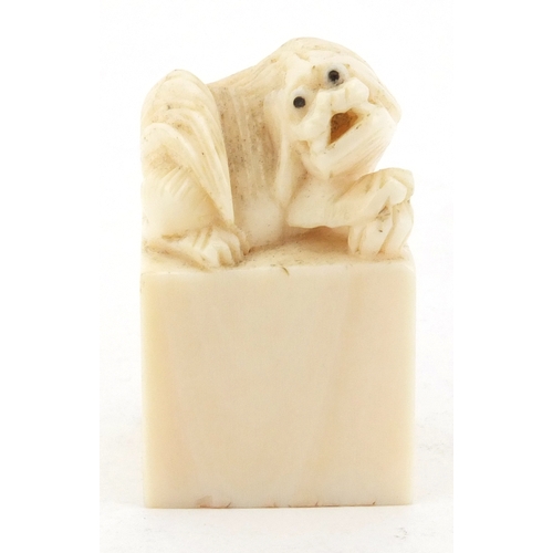 509 - Chinese ivory desk seal carved with a dog of foo, character marks to the base, 4.2cm high