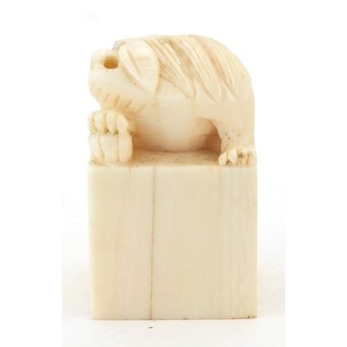 509 - Chinese ivory desk seal carved with a dog of foo, character marks to the base, 4.2cm high