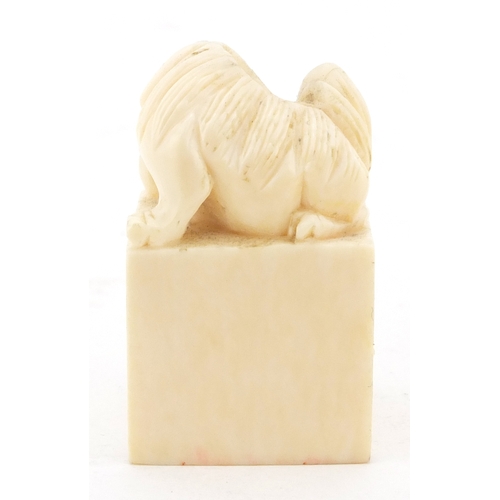 509 - Chinese ivory desk seal carved with a dog of foo, character marks to the base, 4.2cm high