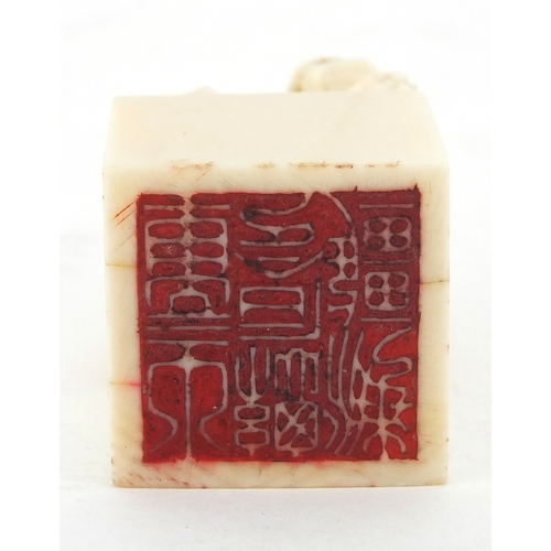 509 - Chinese ivory desk seal carved with a dog of foo, character marks to the base, 4.2cm high