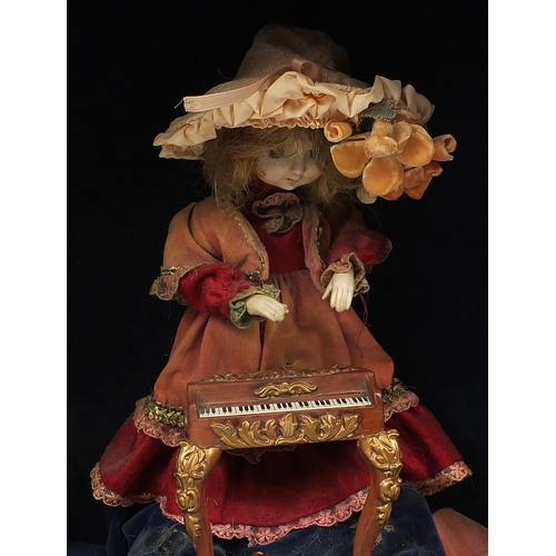 388 - ** DESCRIPTION AMENDED 4/1 ** Automaton musical doll with bisque and hands on a plinth base with can... 