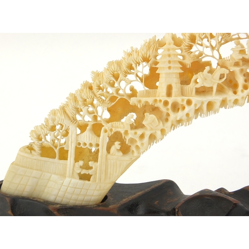 514 - Chinese ivory bridge on hardwood stand, profusely carved with workmen, trees and pagodas, 25cm wide