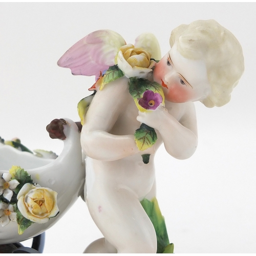 589 - Two 19th century porcelain cherubs, one hand painted and with floral encrusted decoration, the other... 