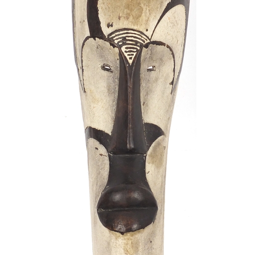 566 - Tribal interest African white painted  carved wooden face mask, 59cm high