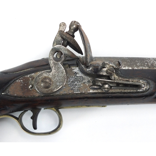 353 - Antique flint lock pistol with brass mounts, engraved Tower, GR emblem and proof marks, initialled T... 