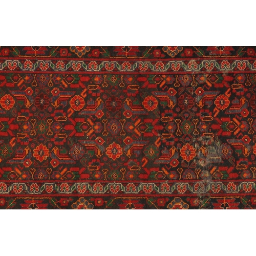 71 - Rectangular Persian Hamadan rug, having all over stylised flowers onto a red and black ground, 215cm... 