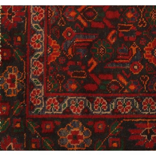 71 - Rectangular Persian Hamadan rug, having all over stylised flowers onto a red and black ground, 215cm... 