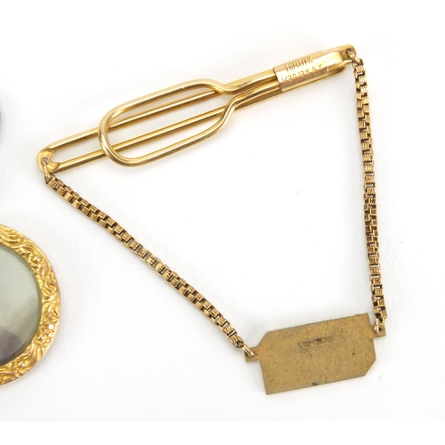 2463 - 9ct gold circular mourning locket and a gold coloured metal tie slide