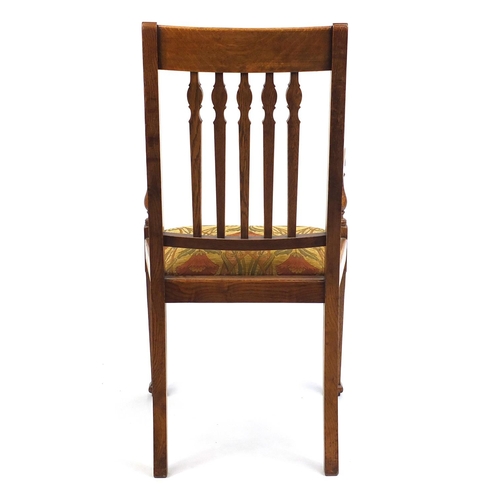 2016 - Oak Arts & Crafts open armchair the padded seat with stylised floral upholstery, 106cm high