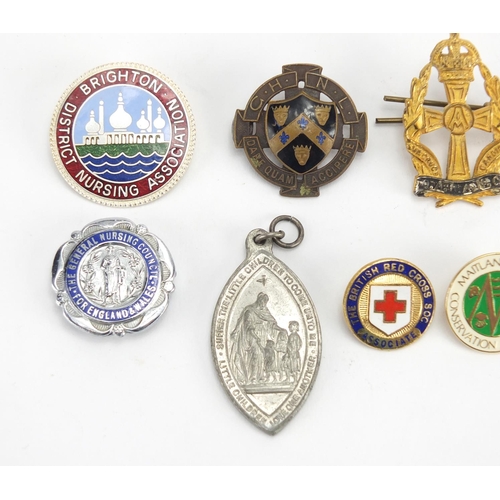 352 - Nine Nursing Association brooches, some enamelled