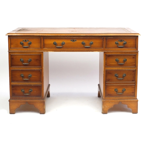 43 - Yew twin pedestal desk with tooled leather top, fitted with a series of drawers, 77cm H x 124cm W x ... 