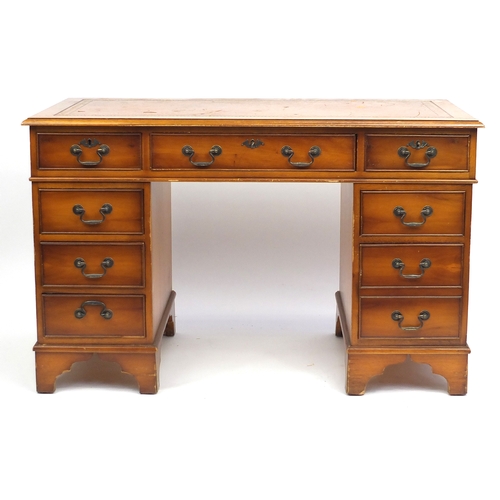 16 - Yew twin pedestal desk with tooled leather top, fitted with a series of drawers, 77cm H x 124cm W x ... 