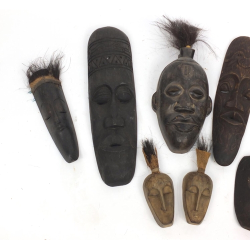 502 - Eight Tribal carved wooden face masks, the largest 61cm high