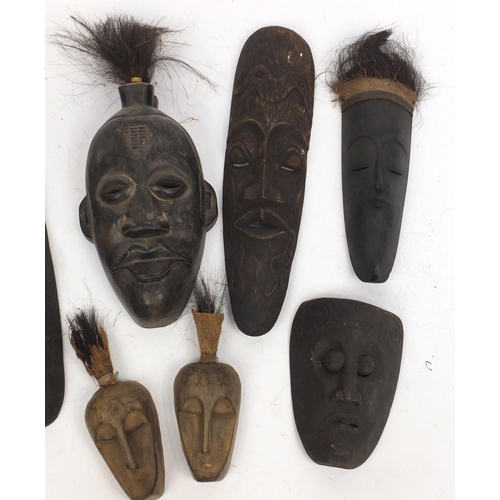 502 - Eight Tribal carved wooden face masks, the largest 61cm high