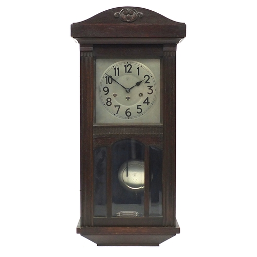 100 - Oak cased Westminster chiming wall clock by Junghans with Arabic numerals, 77cm high