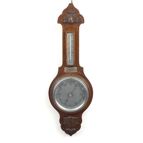 64 - Carved oak aneroid barometer with presentation plaque dated 1957, 67cm in lengh