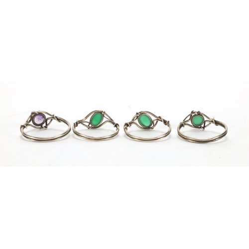 387 - Set of four silver coloured metal napkin rings, three set with cabochon green stones and purple ston... 