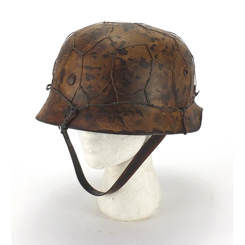718 - German Military interest style helmet with chicken wire and chin strap, impressed 1939