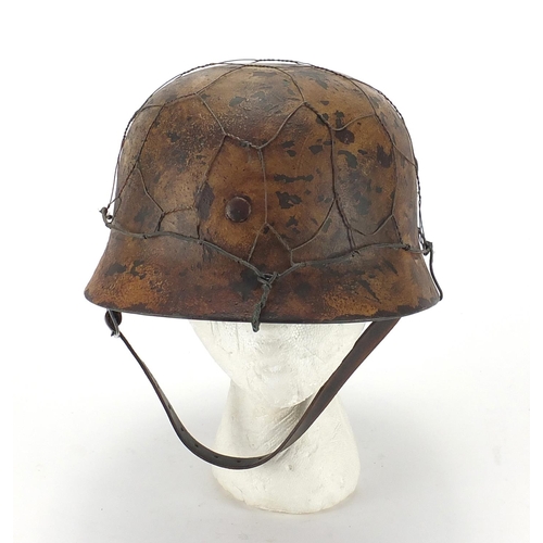 718 - German Military interest style helmet with chicken wire and chin strap, impressed 1939