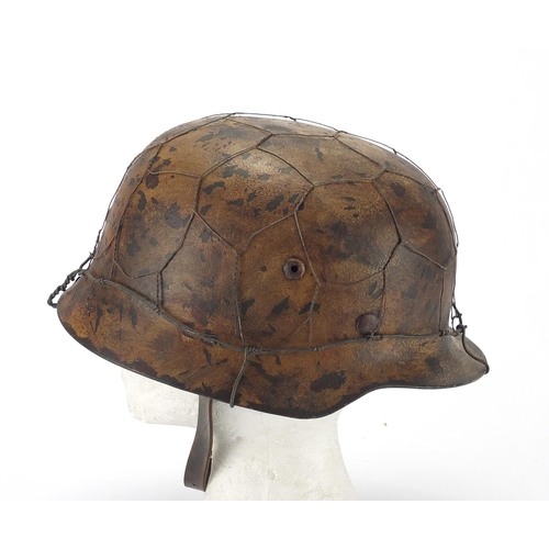 718 - German Military interest style helmet with chicken wire and chin strap, impressed 1939