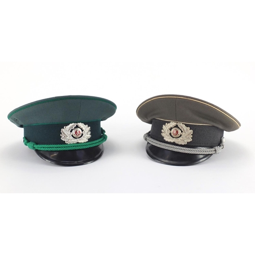 719 - Two  Russian Military interest style peaked caps with Insignia