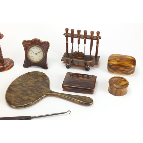 65 - Collection of faux tortoiseshell including hand brushes, pair of candlesticks and a strut clock, the... 