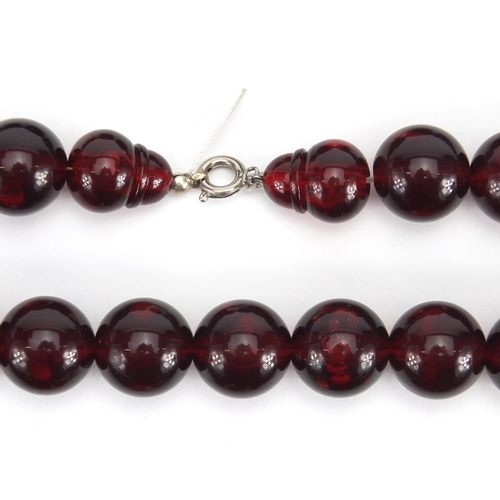 785 - Three cherry amber coloured bead necklaces, the largest 50cm in length, approximate weight 143.0g