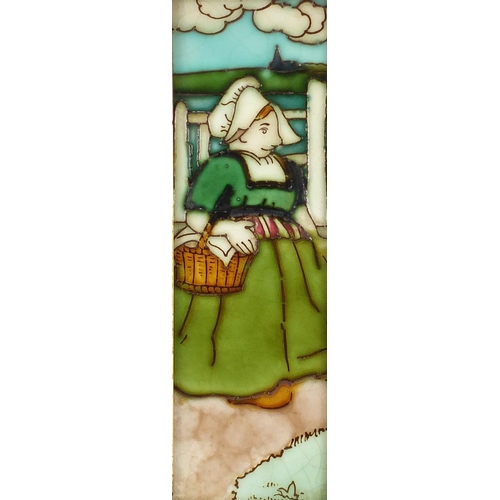 558 - Charlotte Rhead tube lined pottery wall tile, hand painted with lady carrying a basket, housed in an... 