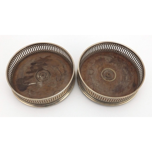 640 - Pair of circular silver and oak wine coasters with pierced decoration, A C & S L D London 1979, 13cm... 