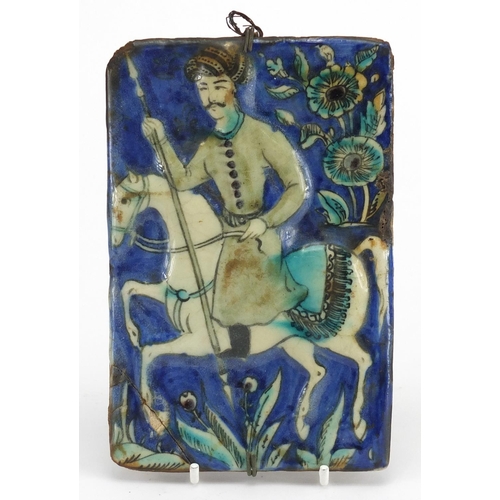 489 - Rectangular Islamic pottery tile hand painted with a figure on horseback, 18cm x 12cm