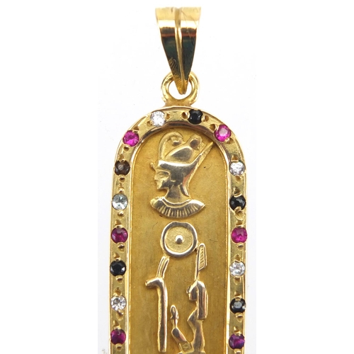 696 - Egyptian gold pendant decorated in relief with hieroglyphics and set with colourful stones, 5.5cm in... 