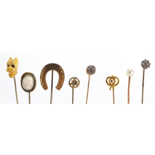 746 - Eight vintage gold and gold coloured metal tie pins including a cameo, horse shoe and pearl examples... 