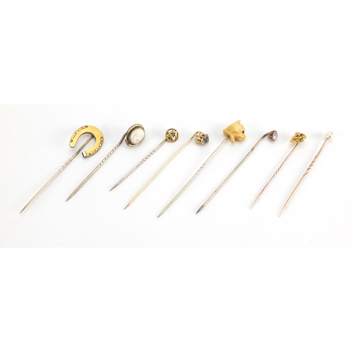 746 - Eight vintage gold and gold coloured metal tie pins including a cameo, horse shoe and pearl examples... 