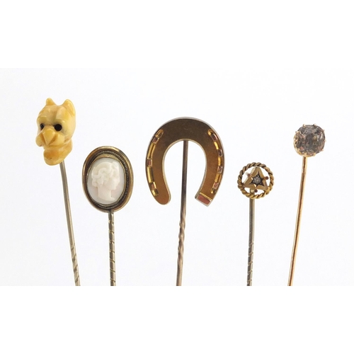 746 - Eight vintage gold and gold coloured metal tie pins including a cameo, horse shoe and pearl examples... 