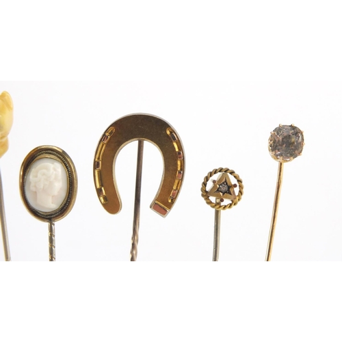 746 - Eight vintage gold and gold coloured metal tie pins including a cameo, horse shoe and pearl examples... 