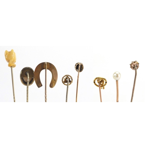 746 - Eight vintage gold and gold coloured metal tie pins including a cameo, horse shoe and pearl examples... 